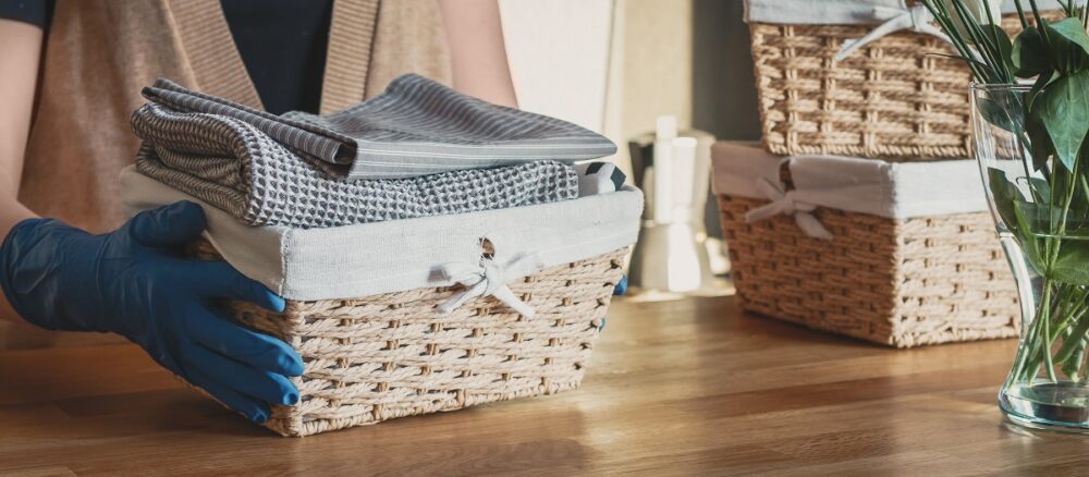 Girl spring cleaning in the kitchen. Piles kitchen towels in baskets. Spring cleaning, decluttering, cleaning space, cleaning agency