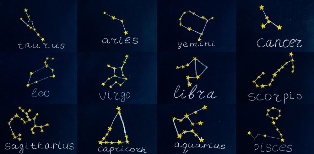 constellations of zodiac signs drawn in chalk and sequins in the form of a check on a chalkboard collage