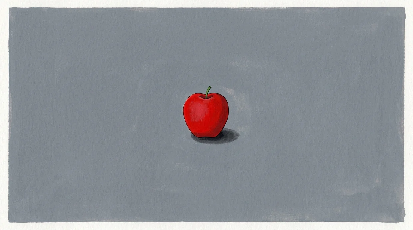 A single red apple centered in a large empty grey space, representing singular focus.